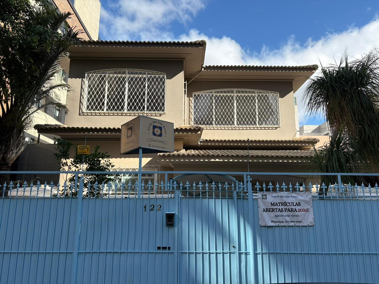 Fachada da Escola São João Bosco com céu azul
